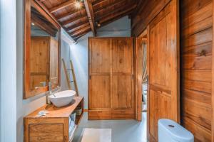 uma casa de banho com armários de madeira e um lavatório em Villa Sejaki - Beautiful 1-bdr villa nearby Seseh Beach em Munggu