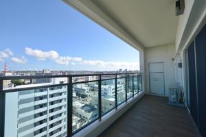ein Balkon mit Blick auf die Stadt in der Unterkunft BRANCHERA NAHA AKEBONO PREMIST 1206 in Naha