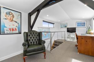 Habitación con silla, escritorio y TV. en Highbury Coastal Villa, en Rye