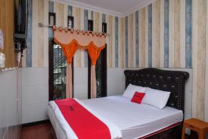 1 dormitorio con 1 cama con manta roja en RedDoorz Syariah near Gardu Pandang Dieng en Kejajar