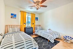 2 bedden in een kamer met een plafondventilator bij Palm Springs Home with Private Patio Less Than 4 Mi to Dtwn! in Palm Springs