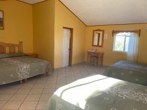 Areponapuchi的住宿－Sierra Hotel，黄色墙壁客房的两张床
