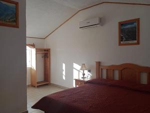 a bedroom with a bed with a red bedspread at Sierra Hotel in Areponapuchi