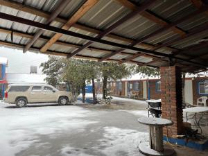 une terrasse couverte avec une voiture garée dans un parking dans l'établissement Sierra Hotel, à Areponapuchi