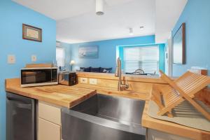 uma cozinha com um lavatório e um micro-ondas no balcão em Beautiful Blue Ocean Condo em Myrtle Beach