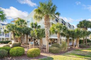 un edificio con palmeras delante en Beautiful Blue Ocean Condo, en Myrtle Beach