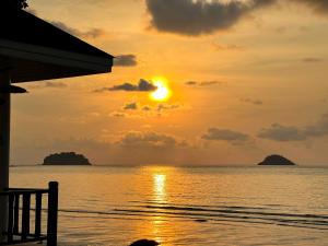 un tramonto sull'oceano con isole in lontananza di Sea Escape Koh Chang a Ko Chang
