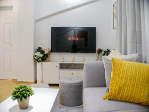 ボラカイにあるFully Furnished 2BR Newly Renovated Apartment by the White Beach - 1min walk from door stepのソファとテレビのあるリビングルーム
