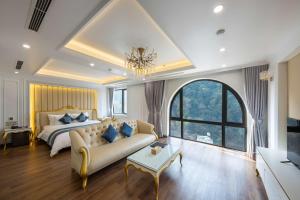 um quarto grande com uma cama e um sofá em Glenda Tower Moc Chau Hotel em Mộc Châu
