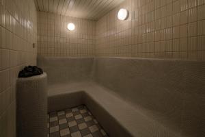 ein Badezimmer mit einer Badewanne mit zwei Leuchten in der Unterkunft Biwako Hotel in Ōtsu