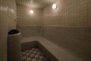 a bathroom with a bath tub with two lights at Biwako Hotel in Otsu