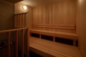 uma sauna com prateleiras de madeira e uma luz na parede em Biwako Hotel em Otsu