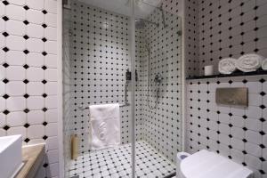 a bathroom with a shower with a toilet and a sink at Yi Stack Hotel Beijing in Beijing