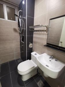 a bathroom with a toilet and a sink and a mirror at D Putra Suites @ IOI Mall Kulai in Kulai