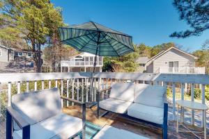 a pair of chairs and an umbrella on a deck at Town of South Bethany --- 125 Elizabeth Way in Bethany Beach