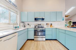 a blue kitchen with white counters and blue cabinets at Town of South Bethany --- 125 Elizabeth Way in Bethany Beach