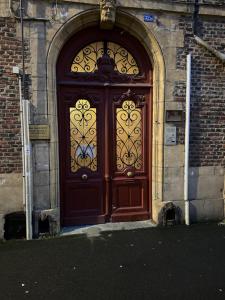 a large wooden door in a brick building at Superbe T2 à 200m de la Place ducale in Charleville-Mézières