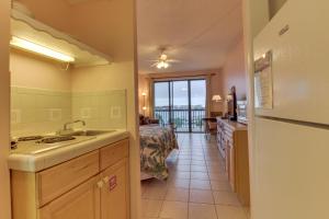 a kitchen with a sink and a room with a bed at Pirates Bay A415 in Fort Walton Beach