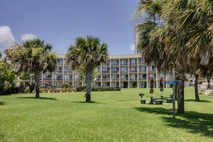 a large building with palm trees in a park at Pirates Bay A415 in Fort Walton Beach