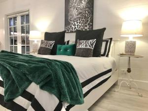 une chambre avec un lit avec une couverture verte dessus dans l'établissement Hamptons In Rye Green Cottage 3 Mins to Hot Springs!, à Rye
