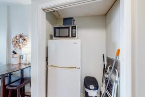 a microwave on top of a refrigerator in a kitchen at Pirates Bay A309 in Fort Walton Beach