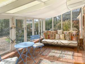 a screened in porch with a couch and chairs at The Green House in West Ashby