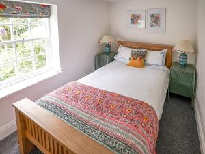 um quarto com uma cama com duas mesas de cabeceira e duas janelas em The Green House em West Ashby