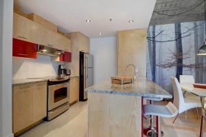 cocina con armarios de madera y encimera en Les Immeubles Charlevoix - Le 760204 en Quebec
