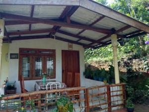 a porch of a house with a table on it at Ella j villa in Ella