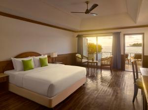 ein Schlafzimmer mit einem großen weißen Bett mit grünen Kissen in der Unterkunft Villa Park Sun Island Resort in Maamigili