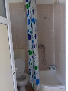 a bathroom with a toilet and a shower curtain at Vila Zaya Saturn in Saturn