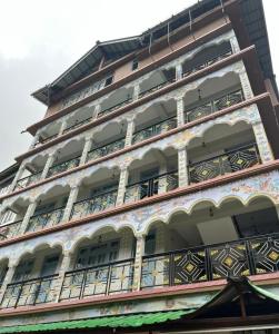 a tall building with balconies on the side of it at Mount Khang Hotel in Lachen