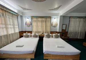 拉臣的住宿－Mount Khang Hotel，两张床铺,位于带窗帘的房间