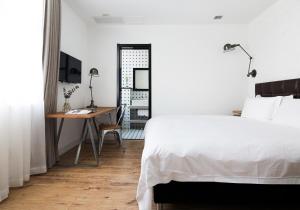 a white bedroom with a desk and a bed at Yi Stack Hotel Beijing in Beijing