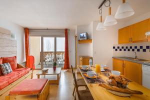 a kitchen and living room with a table and a couch at Lagrange Vacances Les Pics d'Aran in Luchon