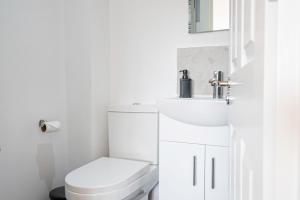 bagno bianco con servizi igienici e lavandino di Luxury Holiday Home Free Parking By the Beach a Warden