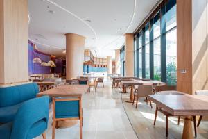 a restaurant with wooden tables and chairs and windows at Dream Dragon Resort in Ðoài Thôn