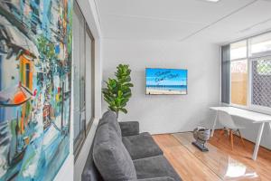 a living room with a couch and a table at Stylish Beachside Comfort Your Brighton Retreat in Brighton