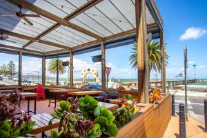 a restaurant with tables and chairs and a pier at Stylish Beachside Comfort Your Brighton Retreat in Brighton