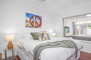 a white bedroom with a bed and a window at Stylish Beachside Comfort Your Brighton Retreat in Brighton