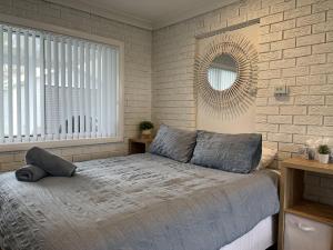 Schlafzimmer mit einem Bett und einem Spiegel an der Wand in der Unterkunft ADEL86 - Twin Rivers in Greenwell Point