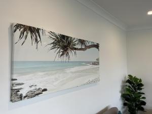 ein Bild eines Strandes mit einer Palme an der Wand in der Unterkunft ADEL86 - Twin Rivers in Greenwell Point