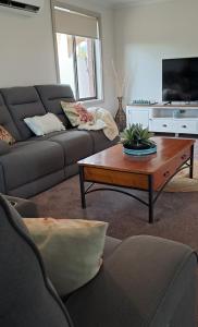 sala de estar con sofá y mesa de centro en Cummins Cottage, en Broken Hill