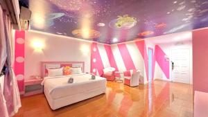 een slaapkamer met een wit bed en een plafond met planeten bij The Wai Hotel Danok in Sadao