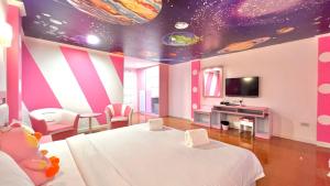 Cette chambre comprend un lit blanc et un plafond avec des planètes. dans l'établissement The Wai Hotel Danok, à Sadao