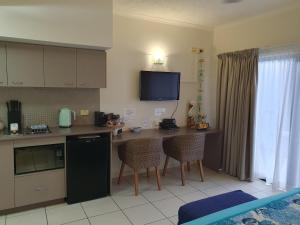 a kitchen with a counter and a table with chairs at Jackies Studio Apartment in Cairns