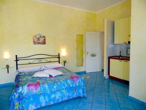 a bedroom with a large bed and a kitchen at Dimora Carlo III in Vietri sul Mare