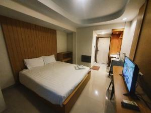 a bedroom with a bed and a flat screen tv at PN Inn Hotel Pattaya in Pattaya South