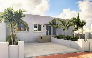 a white house with palm trees in front of it at Turquoise Villa in Paradijs