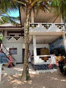 un bâtiment avec un palmier en face dans l'établissement Chandi Gaya Beach Guesthouse, à Tangalle